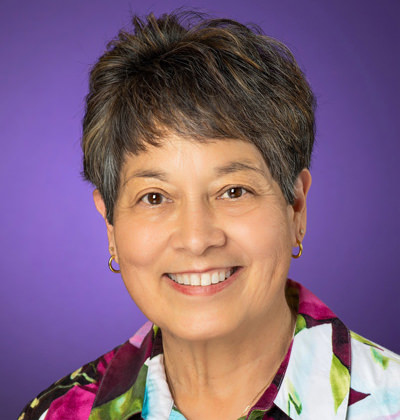 Dr. Lynn Jackson poses in front of a TCU Purple backdrop